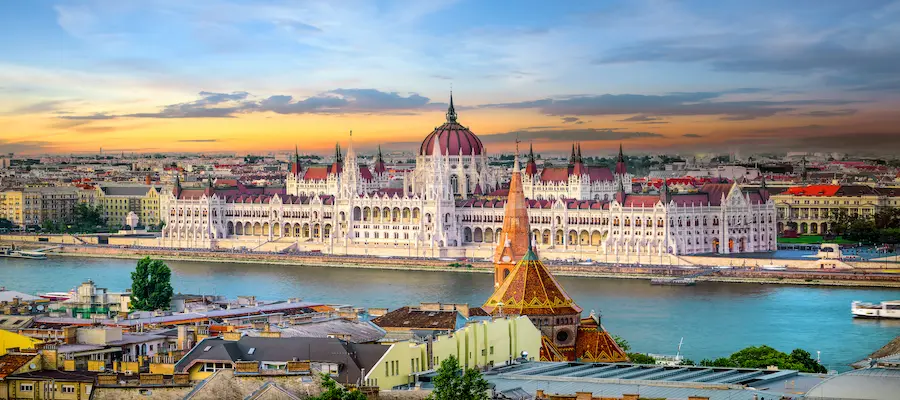 Cer de culoarea piersicii deasupra Országház și Dunării, escapadă Budapesta Ungaria - oferte hoteluri TravelTheme