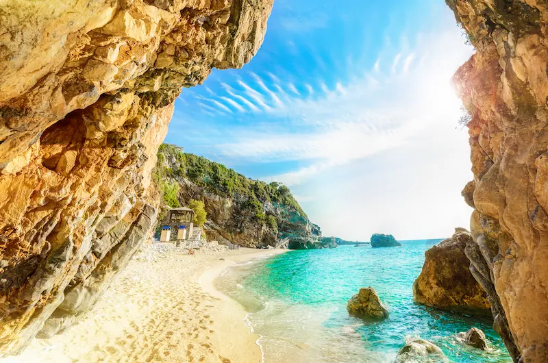 Ape smarald între formațiuni stâncoase gălbui, plaja Mylopotamos accesibilă din Corfu - rezervare hoteluri