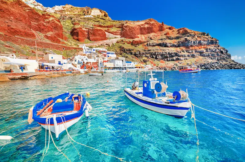 Bărci de pescuit ancorate lângă stânca roșie a caldeirei, satul Ammoudi sub Oia - cazare hotel Santorini
